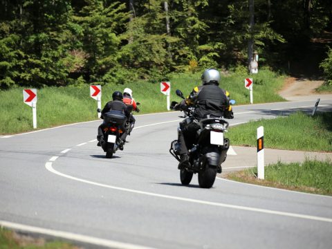 Gruppe von Motorradfahrern auf einer kurvenreichen Landstraße